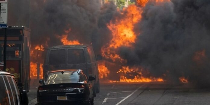 Vehículo incendiado y en llamas cerca de la estatua del Toro de Wall Street en Nueva York, tras la explosión registrada el 19 de mayo de 2026.