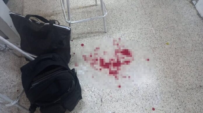 Escena del aula con manchas de sangre en el piso, pupitres y una mochila abandonada después del apuñalamiento al maestro en Huimanguillo