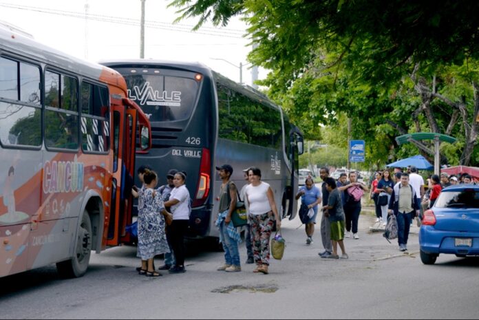 Pasajeros abordan autobuses de transporte público en una parada de Cancún, Quintana Roo, mientras el estado asume el servicio por 15 años.