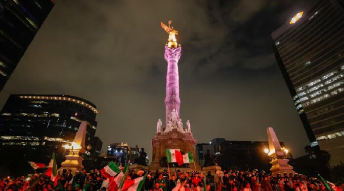 Miles de aficionados mexicanos celebran con banderas, cánticos y bebidas alrededor del Ángel de la Independencia tras el triunfo de México en el partido inaugural del Mundial 2026.
