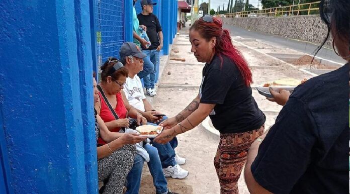 Patricia Negrete Tafoya participa en una jornada de apoyo a familiares de personas desaparecidas, entregando alimentos durante una actividad.