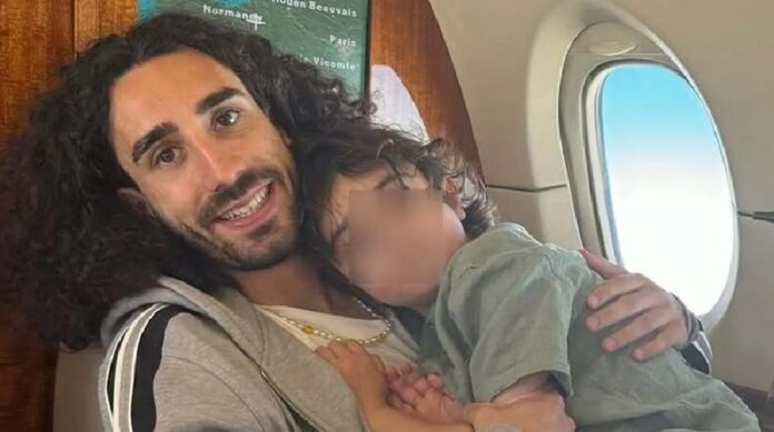 Marc Cucurella sostiene en brazos a su hijo Mateo durante un vuelo