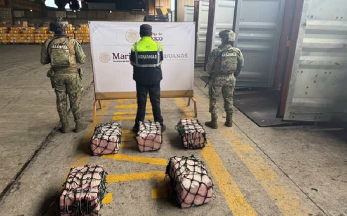 Elementos de la Marina y personal de Aduanas resguardan paquetes de presunta cocaína asegurados durante un operativo en el puerto de Lázaro Cárdenas, Michoacán.