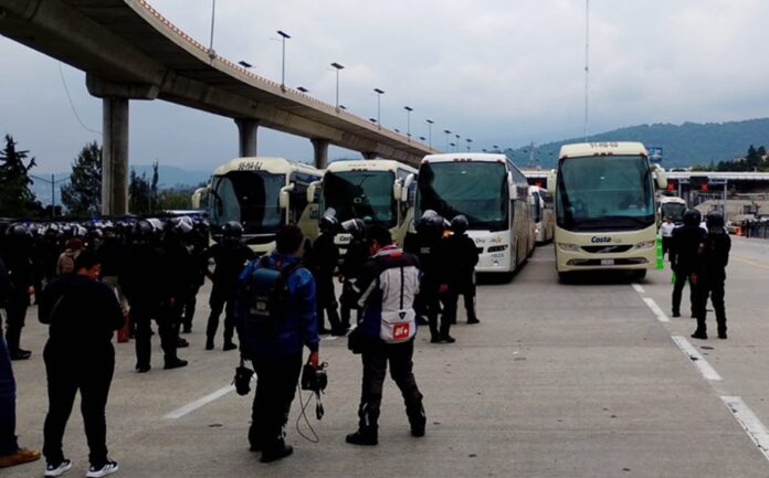 Autobuses con maestros y estudiantes normalistas retenidos por policías en un operativo de revisión en la carretera México-Cuernavaca.