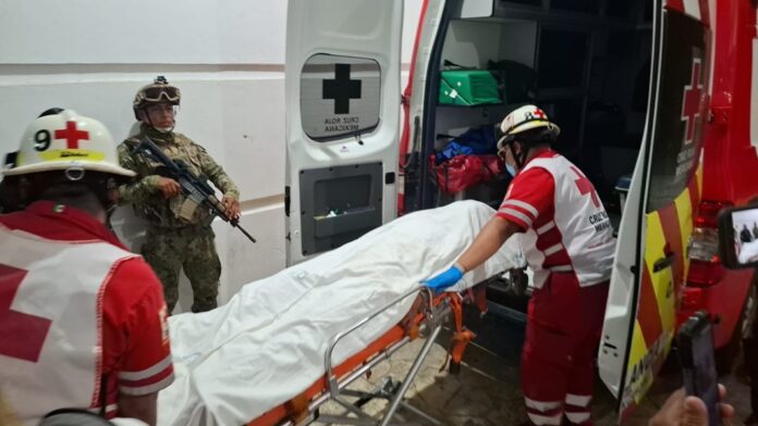 Paramédicos de la Cruz Roja trasladan a uno de los lesionados tras el enfrentamiento entre un extranjero y un presunto asaltante en Cancún.