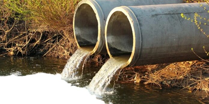 Descarga de aguas residuales en un cuerpo de agua; autoridades advierten que las empresas responsables pueden recibir multas millonarias por contaminación ambiental.