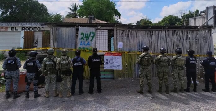 Elementos de la Fiscalía, Marina, Ejército y corporaciones de seguridad resguardan un inmueble cateado durante un operativo realizado en Quintana Roo.