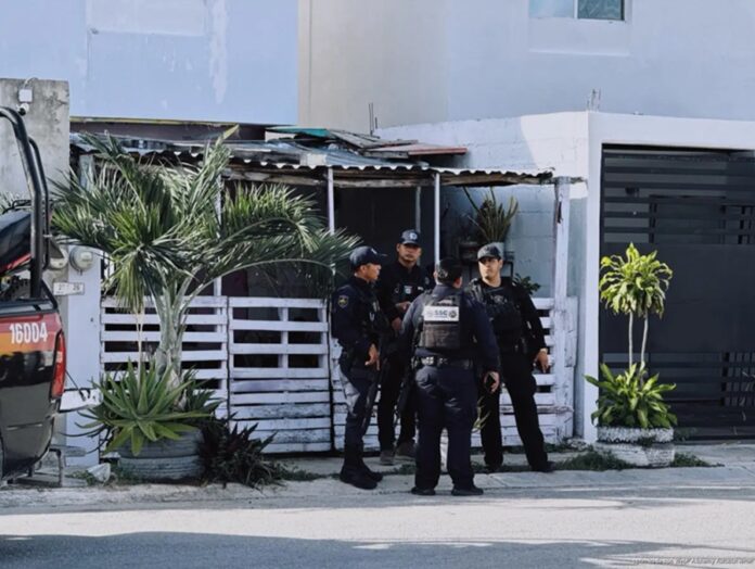 Elementos de la Secretaría de Seguridad Ciudadana resguardan una vivienda del fraccionamiento Paseos Kusamil, en Cancún, donde rescataron a tres hombres privados de la libertad durante un operativo conjunto.