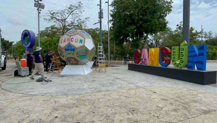 Balón gigante decorativo inspirado en el Mundial 2026 es instalado junto al letrero de Cancún en el Malecón Tajamar como parte del ambiente futbolero rumbo al torneo.