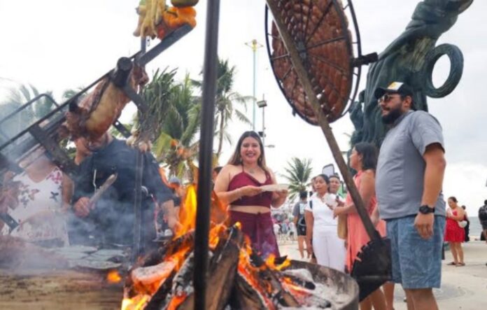 Visitantes disfrutan comida a la parrilla frente al mar durante Playa Grill Fest en Parque Fundadores.