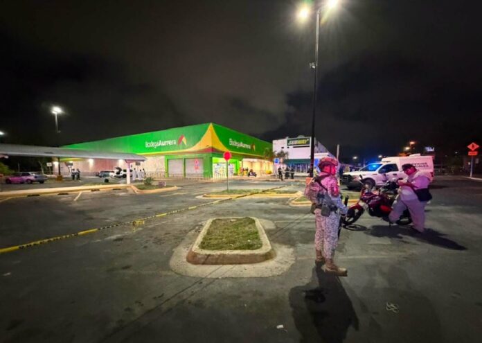 Elementos de seguridad resguardan el estacionamiento de una tienda de autoservicio en Playa del Carmen tras un ataque armado que dejó una persona sin vida.
