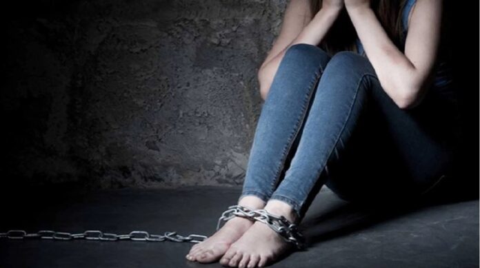 Imagen ilustrativa de una mujer sentada con cadenas en los tobillos, utilizada para representar la lucha contra la trata de personas y la explotación humana.