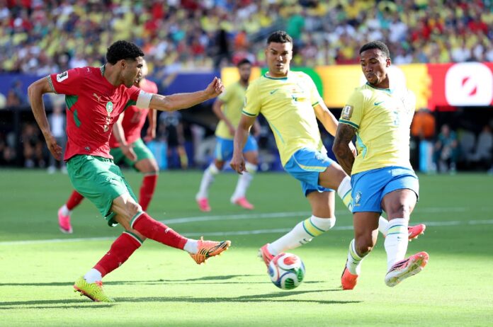 Jugador de Marruecos dispara al arco ante la marca de futbolistas de Brasil durante el partido del Grupo C del Mundial 2026