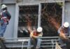 México busca frenar nuevo arancel de EE. UU. por acusaciones de trabajo forzoso Trabajadores de la construcción realizan labores de soldadura y corte sobre una estructura metálica en altura.