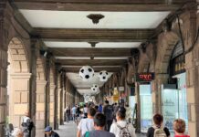 Moody’s enfría expectativas del Mundial: llegarían menos turistas extranjeros Personas caminan bajo un corredor del Centro Histórico decorado con balones gigantes de futbol rumbo al Mundial 2026.
