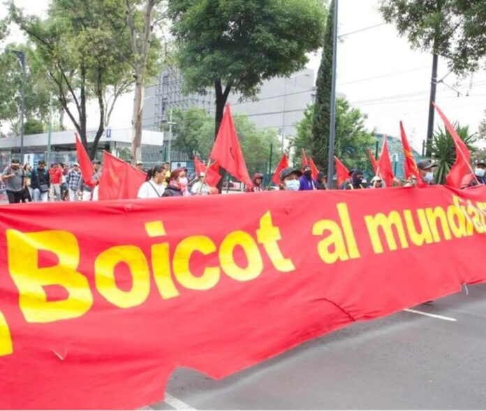 Integrantes de la CNTE marchan con pancartas y banderas durante una protesta en calles de la Ciudad de México, previo a la inauguración del Mundial 2026.