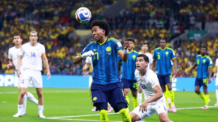 Jugador de Colombia disputa un balón aéreo ante futbolistas de Uzbekistán durante el partido del Mundial 2026.