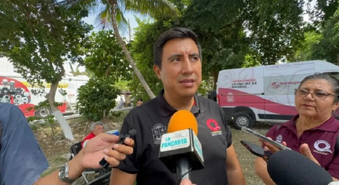 Rafael Hernández Kotasek, director general del IMOVEQROO, ofrece una entrevista sobre las acciones contra la falsificación de licencias de conducir en Quintana Roo, frente a una unidad móvil de trámites.