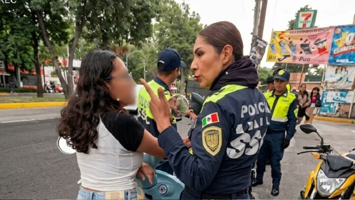 Agente de Tránsito y motociclista forcejean durante un operativo vial sobre Insurgentes Sur, mientras otros policías observan la escena en plena avenida de la Ciudad de México.