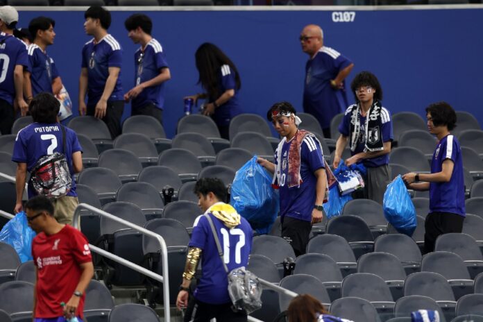 Aficionados de Japón recogen basura en las gradas del Estadio Dallas utilizando bolsas azules tras el partido ante Países Bajos en el Mundial 2026.