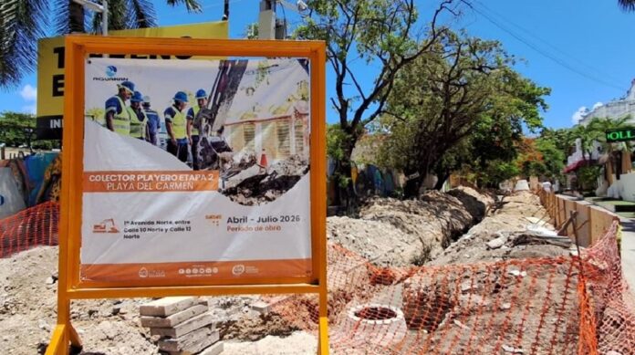 Obra del colector playero de Aguakan sobre la Primera Avenida Norte de Playa del Carmen, con excavaciones y señalización en una zona turística y comercial.