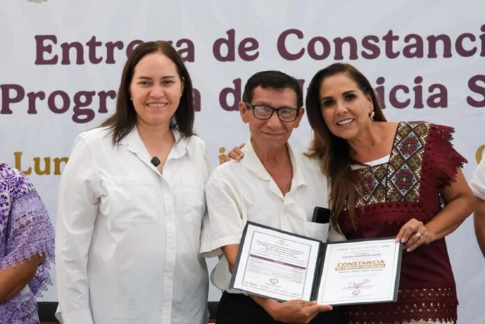 La gobernadora Mara Lezama y la vocal ejecutiva del FOVISSSTE entregan una constancia de finiquito y cancelación de hipoteca a un beneficiario durante un evento realizado en Chetumal.