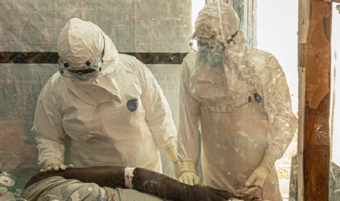 Personal médico con equipos de protección biológica atiende a un paciente durante protocolos sanitarios relacionados con un caso de ébola.