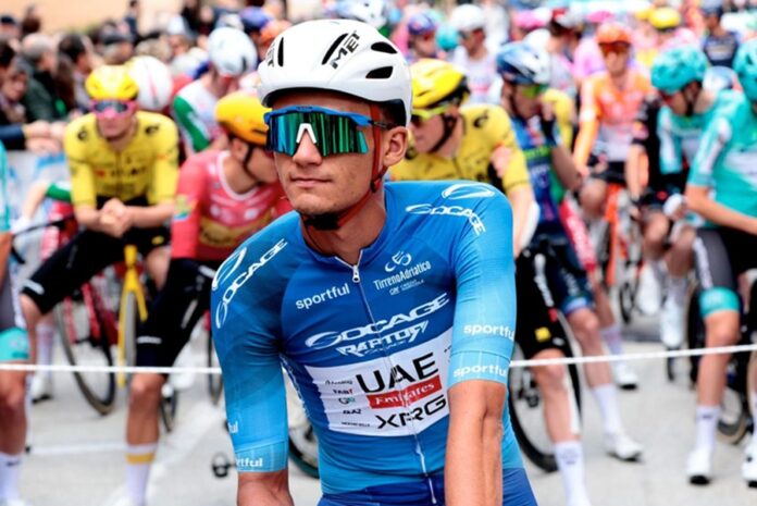 El ciclista mexicano Isaac del Toro, del UAE Team Emirates, espera la salida de una etapa rodeado por el pelotón durante una competencia internacional de ciclismo.