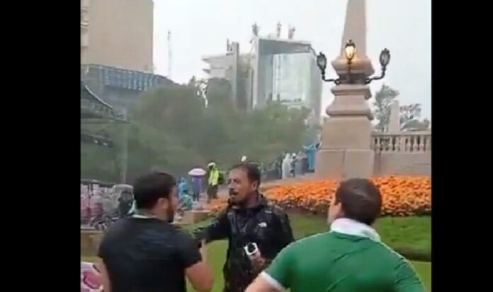 Aficionados cubiertos con una manta que contiene fichas de búsqueda de personas desaparecidas durante los festejos del Mundial 2026 en el Ángel de la Independencia.