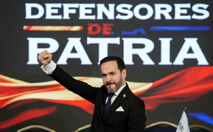 Abelardo de la Espriella levanta el puño durante un evento con un fondo que dice Defensores de Patria.