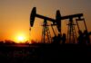 OPEP+ acuerda nuevo aumento de producción petrolera en medio de temores por sobreoferta global Bombas extractoras de petróleo operan al atardecer en un campo petrolero con siluetas industriales.