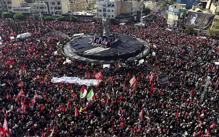 Vista aérea de una multitud reunida durante la procesión fúnebre de Alí Jameneí en una plaza de Teherán, con banderas y pancartas. Foto: Reuters.