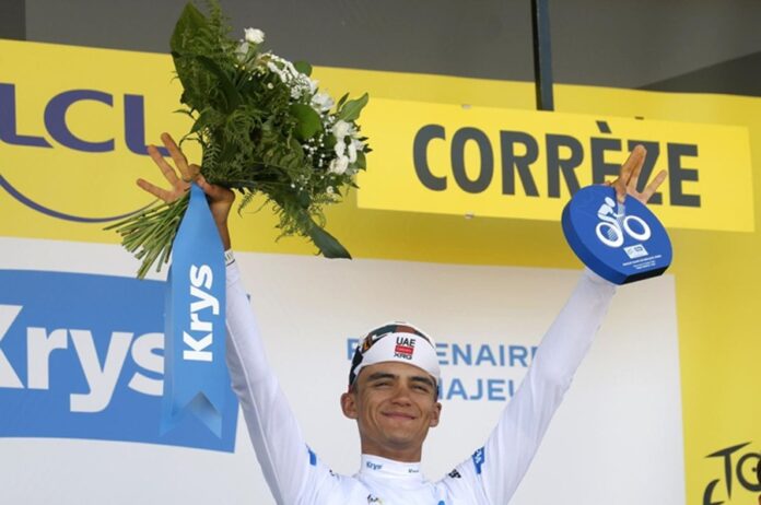 Isaac del Toro levanta un ramo de flores y el trofeo del líder juvenil durante la ceremonia del Tour de Francia.