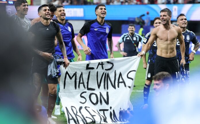 Jugadores de la selección de Argentina sostienen una bandera con la frase Las Malvinas son argentinas tras un partido del Mundial.