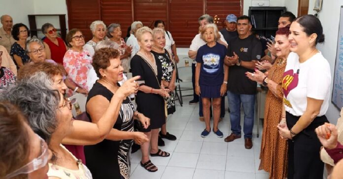 Estefanía Mercado conversa con personas adultas mayores durante un encuentro realizado en Playa del Carmen.