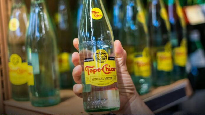 Botellas de Topo Chico, marca propiedad de The Coca-Cola Company, involucrada en un acuerdo reparatorio con autoridades fiscales mexicanas.