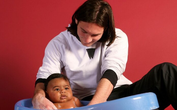 Lionel Messi baña al bebé Lamine Yamal durante una sesión fotográfica organizada por el FC Barcelona y UNICEF.