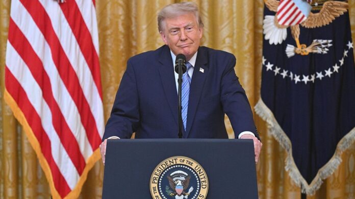 Donald Trump desde atril presidencial con las banderas de Estados Unidos al fondo.