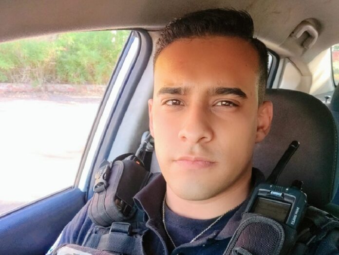 Orlando Maciel posa con uniforme policial dentro de un vehículo mientras observa hacia la cámara.