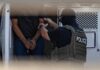 Amnistía Internacional exige investigar muertes de mexicanos bajo custodia de ICE en Estados Unidos Un agente escolta a una persona esposada hacia un vehículo oficial.