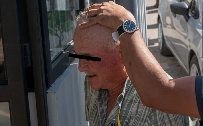 Ernesto Ruffo Appel es escoltado por una persona mientras camina al exterior de un inmueble, durante una diligencia relacionada con el proceso judicial.
