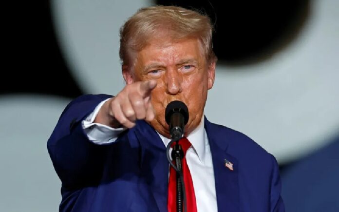 Donald Trump señala hacia el público mientras habla frente a un micrófono durante un acto oficial. Foto: Reuters.