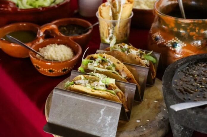 Panuchos y antojitos tradicionales de la cocina yucateca servidos sobre una mesa con salsas y utensilios de barro.