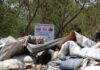 Retiran 97 toneladas de basura de un basurero clandestino en Cancún Montones de basura acumulada en un basurero clandestino de la Supermanzana 200 de Cancún, con un letrero que prohíbe tirar residuos y personal municipal al fondo.