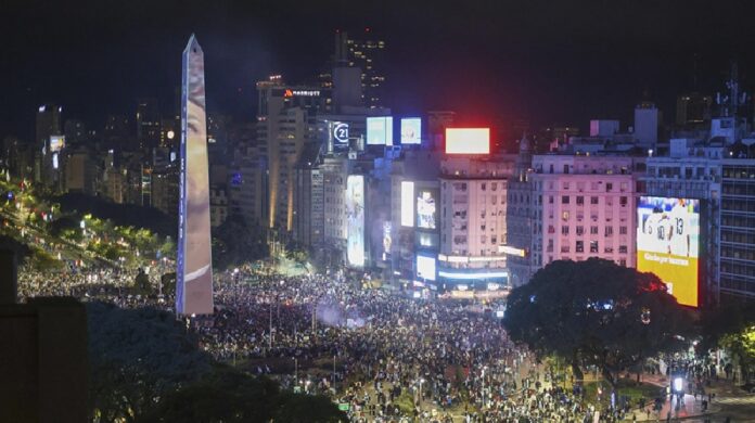 Miles de personas se concentran alrededor del Obelisco de Buenos Aires durante una movilización nocturna en el centro de la ciudad.