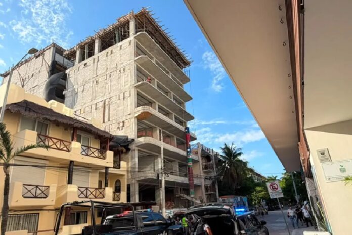 Patrullas de la Policía Municipal permanecen frente a un edificio en construcción durante un operativo tras el reporte de disparos con una pistola de balines en Playa del Carmen.