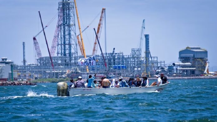 Embarcación navega frente a instalaciones industriales en Topolobampo, Sinaloa, donde existe oposición ambiental al proyecto de una planta de amoniaco.