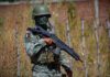 Operativo en Sinaloa deja 10 presuntos agresores muertos y tres detenidos tras enfrentamiento Elemento del Ejército Mexicano con uniforme, casco y arma larga permanece de pie junto a una cerca de alambre.