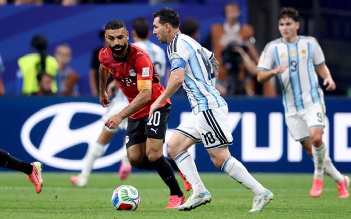 Lionel Messi conduce el balón mientras es marcado por un jugador de Egipto durante un partido del Mundial; al fondo aparecen otros futbolistas argentinos.