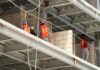 COPARMEX Quintana Roo advierte que revisión del T-MEC exige certeza jurídica para mantener competitividad regional Trabajadores de construcción con chalecos de seguridad dentro de una obra con estructura metálica en proceso de edificación.